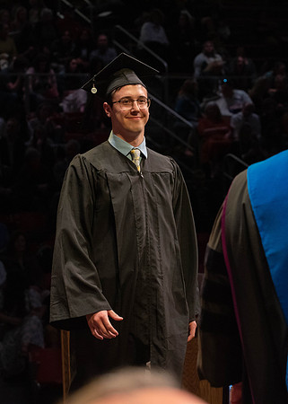 Students graduate and walk to receive their diplomas during convocation in the College of Physical Sciences and Engineering.