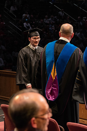 Students graduate and walk to receive their diplomas during convocation in the College of Physical Sciences and Engineering.