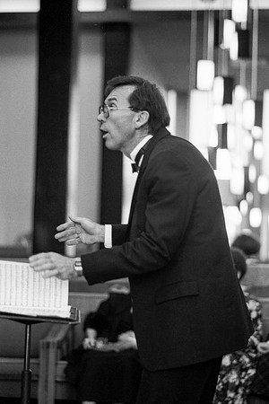 The conductor of the choir leading them through a piece at the Banquet