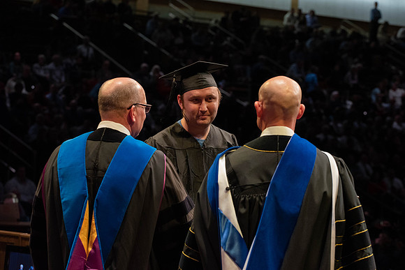 Students graduate and walk to receive their diplomas during convocation in the College of Physical Sciences and Engineering.