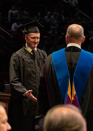 Students graduate and walk to receive their diplomas during convocation in the College of Physical Sciences and Engineering.