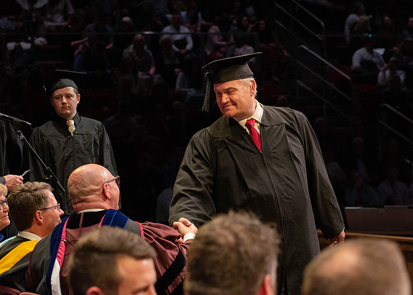 Students graduate and walk to receive their diplomas during convocation in the College of Physical Sciences and Engineering.