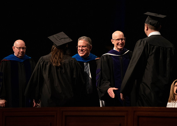 Students graduate and walk to recieve their diplomas during convocation in the College of Business and Communications.