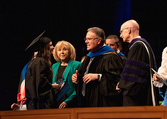 Students graduate and walk to recieve their diplomas during convocation in the College of Business and Communications.