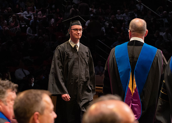 Students graduate and walk to receive their diplomas during convocation in the College of Physical Sciences and Engineering.