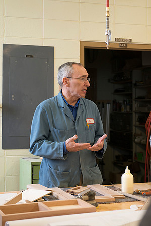 Pat Huish, a wood working instructor, talks with his students about their semester long project of building a clock.