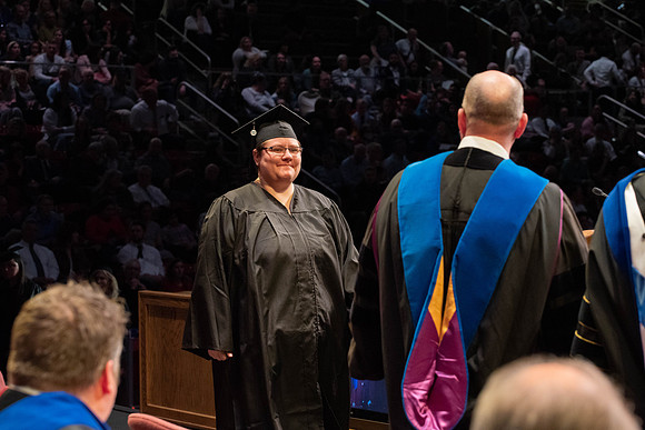 Students graduate and walk to receive their diplomas during convocation in the College of Physical Sciences and Engineering.