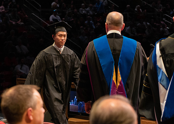 Students graduate and walk to receive their diplomas during convocation in the College of Physical Sciences and Engineering.