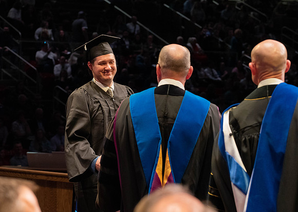 Students graduate and walk to receive their diplomas during convocation in the College of Physical Sciences and Engineering.
