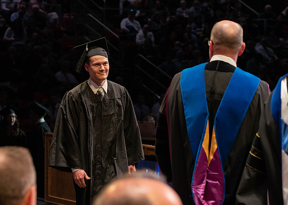 Students graduate and walk to receive their diplomas during convocation in the College of Physical Sciences and Engineering.