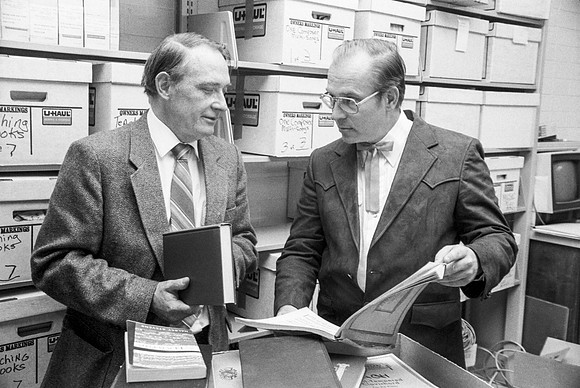 Faculty members looking through archieved books