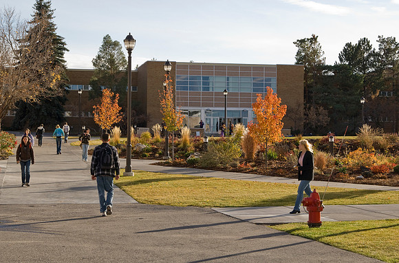 Autumn on the campus of BYU-Idaho. Students walking between buildings with the David O. McKay Library in the background.