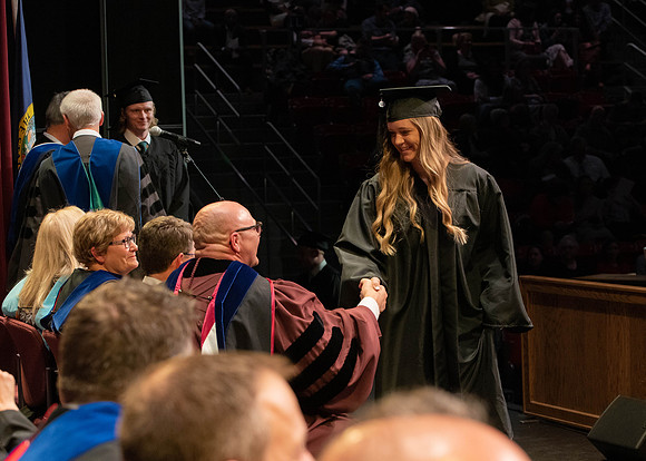 Students graduate and walk to receive their diplomas during convocation in the College of Physical Sciences and Engineering.