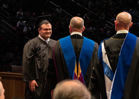 Students graduate and walk to receive their diplomas during convocation in the College of Physical Sciences and Engineering.