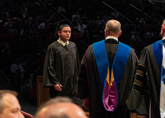 Students graduate and walk to receive their diplomas during convocation in the College of Physical Sciences and Engineering.