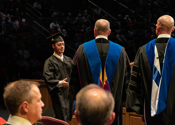 Students graduate and walk to receive their diplomas during convocation in the College of Physical Sciences and Engineering.
