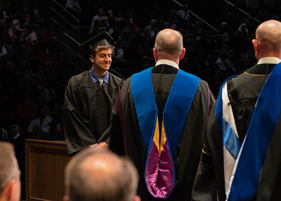 Students graduate and walk to receive their diplomas during convocation in the College of Physical Sciences and Engineering.