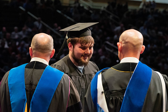 Students graduate and walk to receive their diplomas during convocation in the College of Physical Sciences and Engineering.
