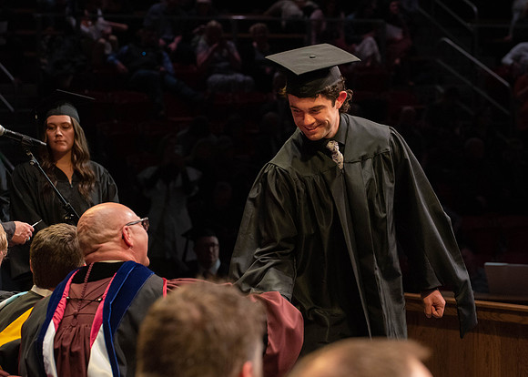 Students graduate and walk to receive their diplomas during convocation in the College of Physical Sciences and Engineering.