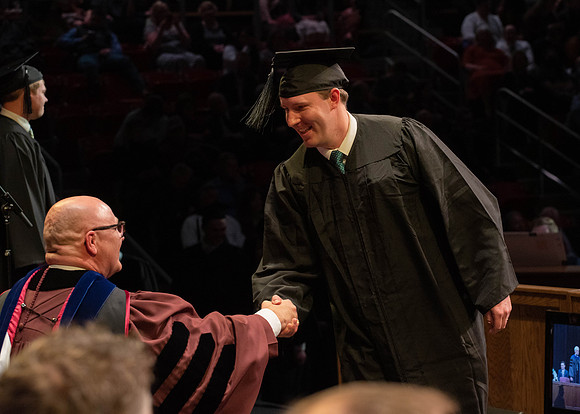 Students graduate and walk to receive their diplomas during convocation in the College of Physical Sciences and Engineering.