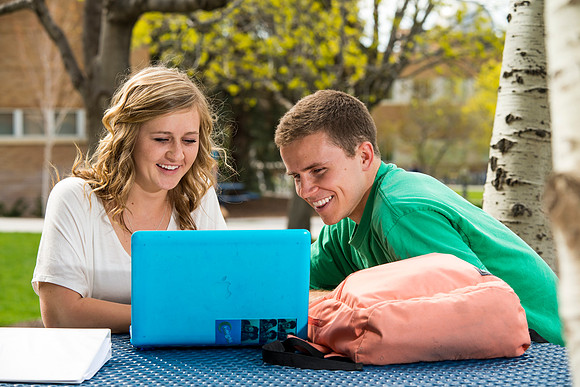 Student models studying at a picnic table on the North side of the Smith Building for Be Smart cover photo options.