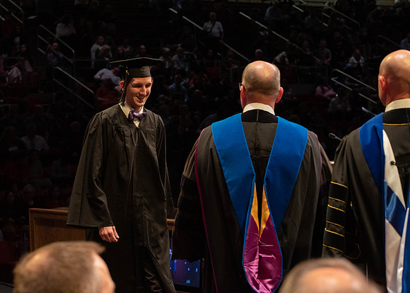 Students graduate and walk to receive their diplomas during convocation in the College of Physical Sciences and Engineering.