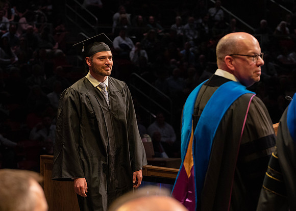 Students graduate and walk to receive their diplomas during convocation in the College of Physical Sciences and Engineering.