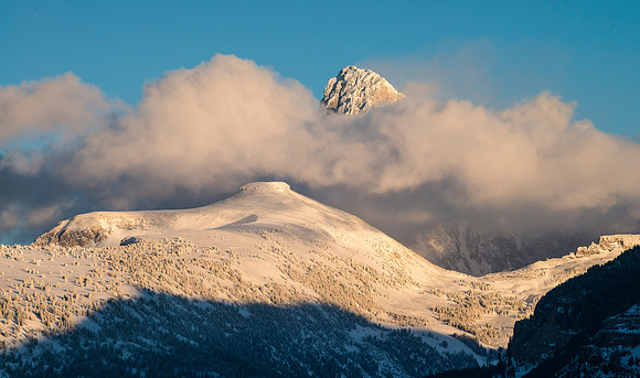 As the setting sun sheds it's last light, Table Rock and the Grand Teton peer through the clouds.