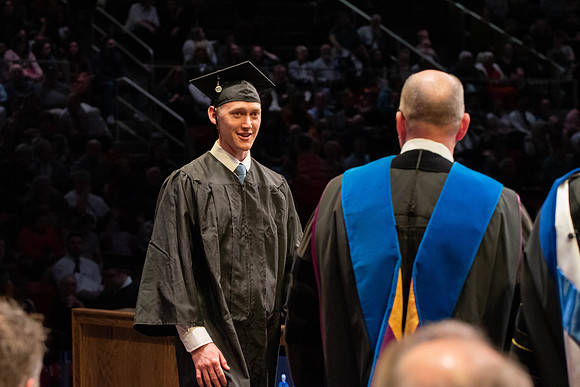 Students graduate and walk to receive their diplomas during convocation in the College of Physical Sciences and Engineering.
