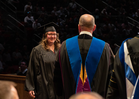 Students graduate and walk to receive their diplomas during convocation in the College of Physical Sciences and Engineering.