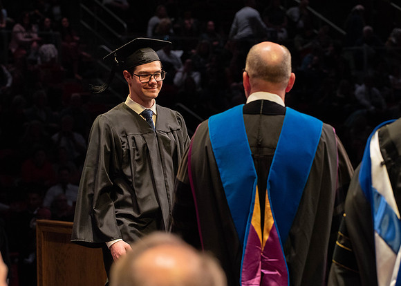 Students graduate and walk to receive their diplomas during convocation in the College of Physical Sciences and Engineering.