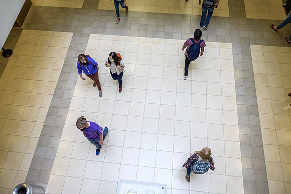 Student volunteers show the way to stay safe during this COVID 19 pandemic by social distancing, following pathway arrows and proper wearing of masks .