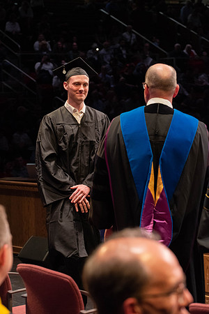 Students graduate and walk to receive their diplomas during convocation in the College of Physical Sciences and Engineering.