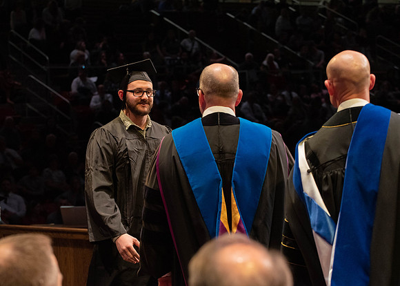 Students graduate and walk to receive their diplomas during convocation in the College of Physical Sciences and Engineering.