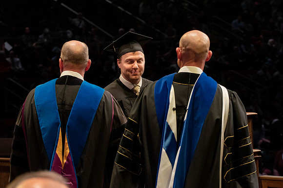 Students graduate and walk to receive their diplomas during convocation in the College of Physical Sciences and Engineering.