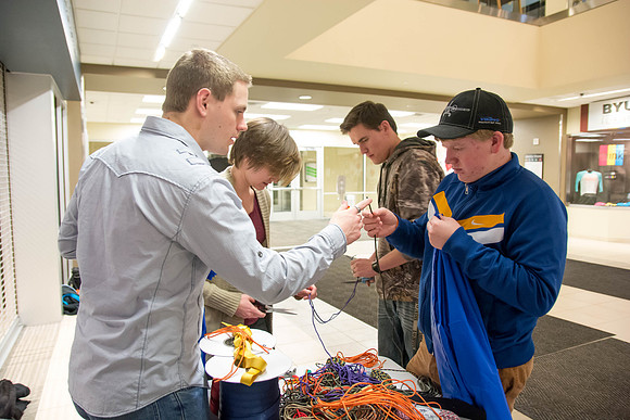 Students learn to make hammocks out of parachute material.