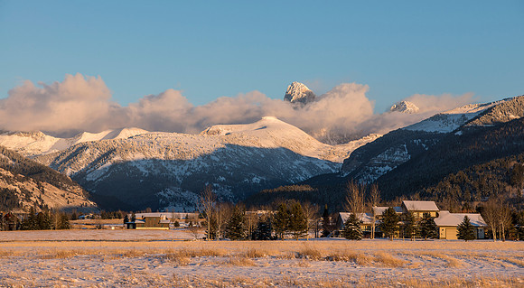 As the setting sun sheds it's last light, Table Rock and the Grand Teton peer through the clouds.