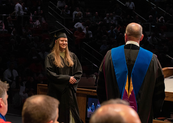 Students graduate and walk to receive their diplomas during convocation in the College of Physical Sciences and Engineering.
