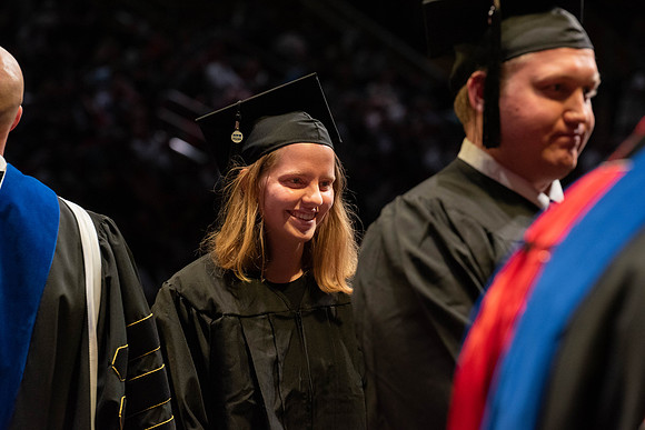 Students graduate and walk to receive their diplomas during convocation in the College of Physical Sciences and Engineering.