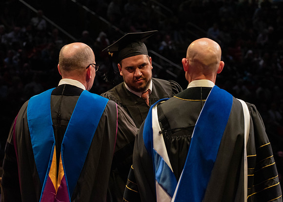 Students graduate and walk to receive their diplomas during convocation in the College of Physical Sciences and Engineering.