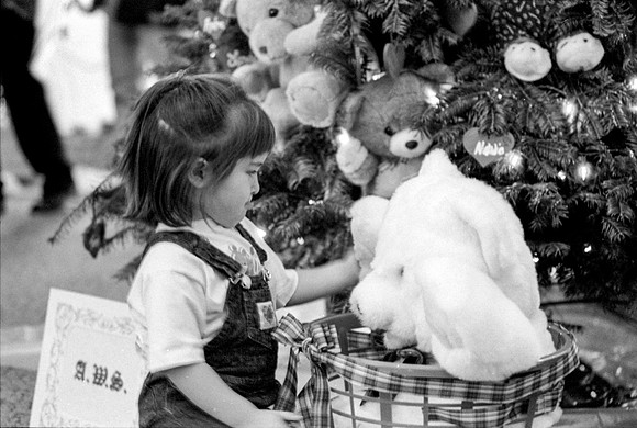 A young girl playing with a teddy bear