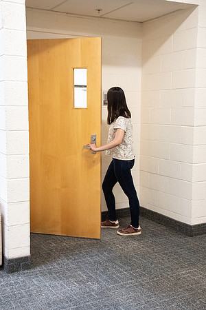 Examples of students staying safe and healthy during the COVID-19 pandemic by social distancing, following pathway arrows, and wearing face masks.