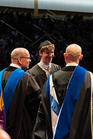 Students graduate and walk to receive their diplomas during convocation in the College of Physical Sciences and Engineering.