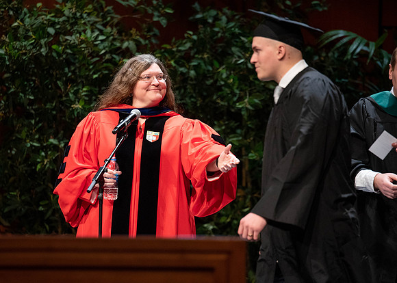 Students graduate and walk to recieve their diplomas during convocation in the College of Business and Communications.