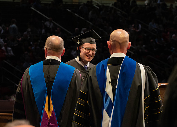 Students graduate and walk to receive their diplomas during convocation in the College of Physical Sciences and Engineering.