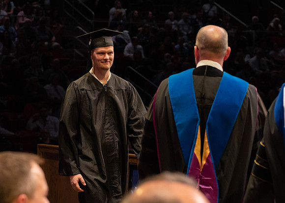 Students graduate and walk to receive their diplomas during convocation in the College of Physical Sciences and Engineering.