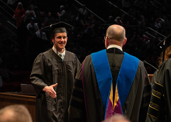 Students graduate and walk to receive their diplomas during convocation in the College of Physical Sciences and Engineering.