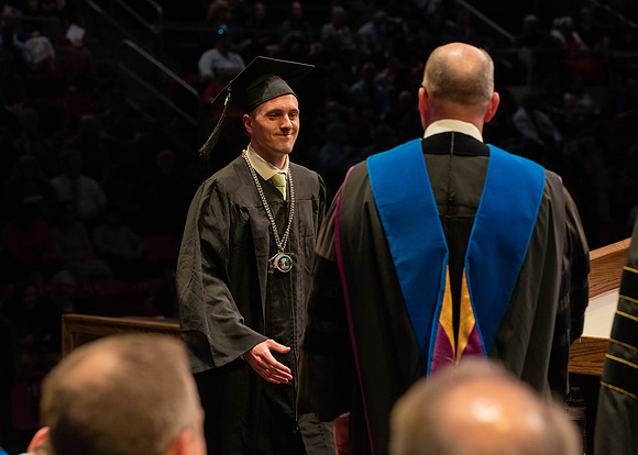 Students graduate and walk to receive their diplomas during convocation in the College of Physical Sciences and Engineering.