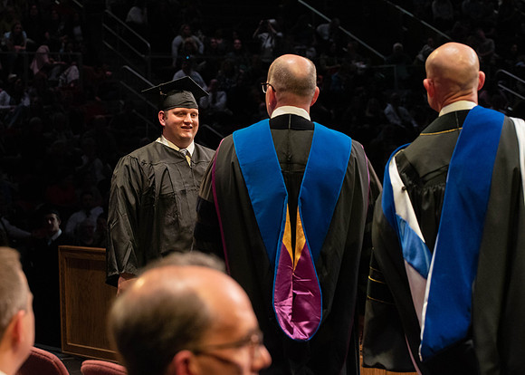 Students graduate and walk to receive their diplomas during convocation in the College of Physical Sciences and Engineering.