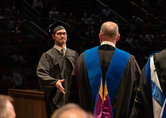 Students graduate and walk to receive their diplomas during convocation in the College of Physical Sciences and Engineering.
